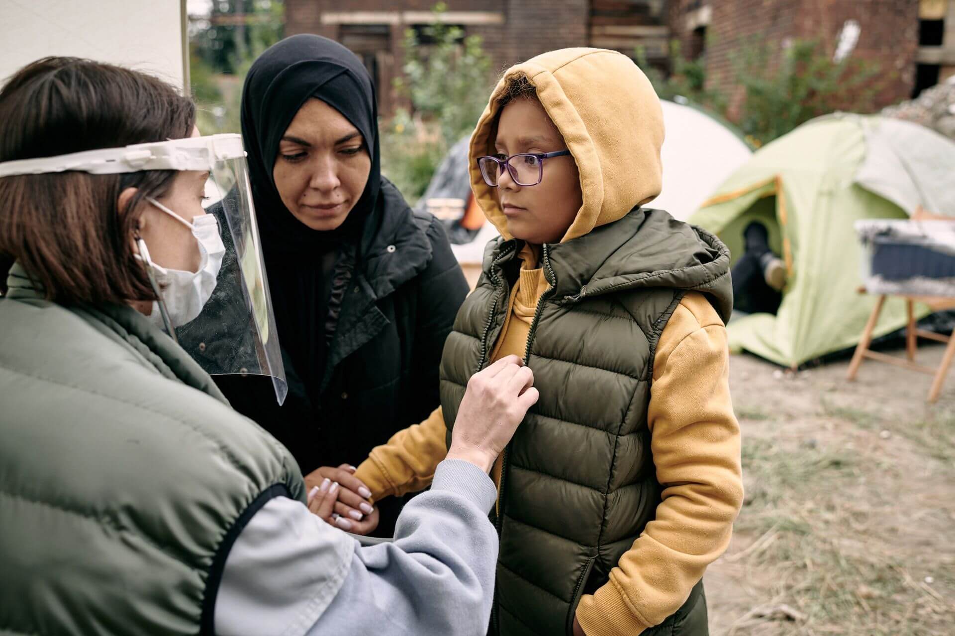 young volunteer protective mask screen examining little girl